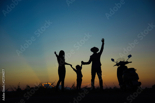 Happy family together  parents with their little child at sunset