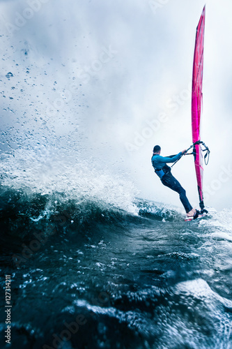 windsurfer at high speed surfing towards the horizon