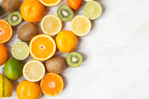 Fruits reach in vitamin C: oranges, lemons, limes, clementines, kiwis, top view, selective focus © Liliya Trott