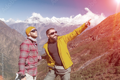 Two outdoor Men staying on Mountain Trail pointing old style