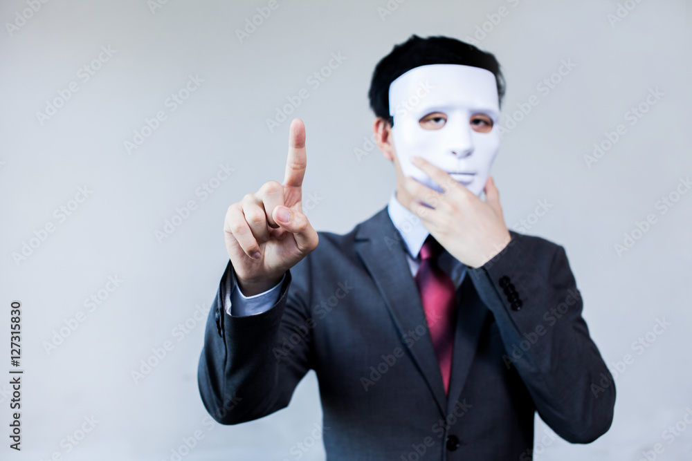 Anonymous businessman in mask hiding himself touching on virtual screen - with copyspace Anonymous businessman in mask hiding himself touching on virtual screen - with copyspace