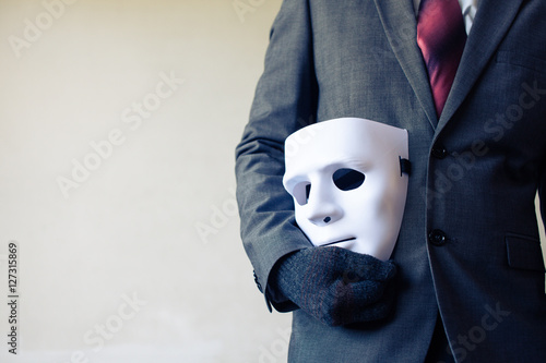 Fotografering Business man carrying white mask to his body indicating Business fraud and fakin