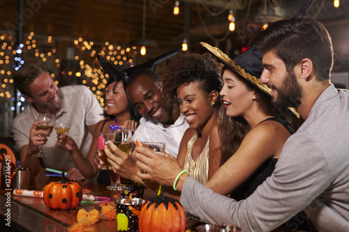 Photography Friends enjoying a Halloween party at a bar making a toast