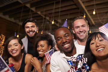 Friends with US flags at a 4th July party in a bar, close up