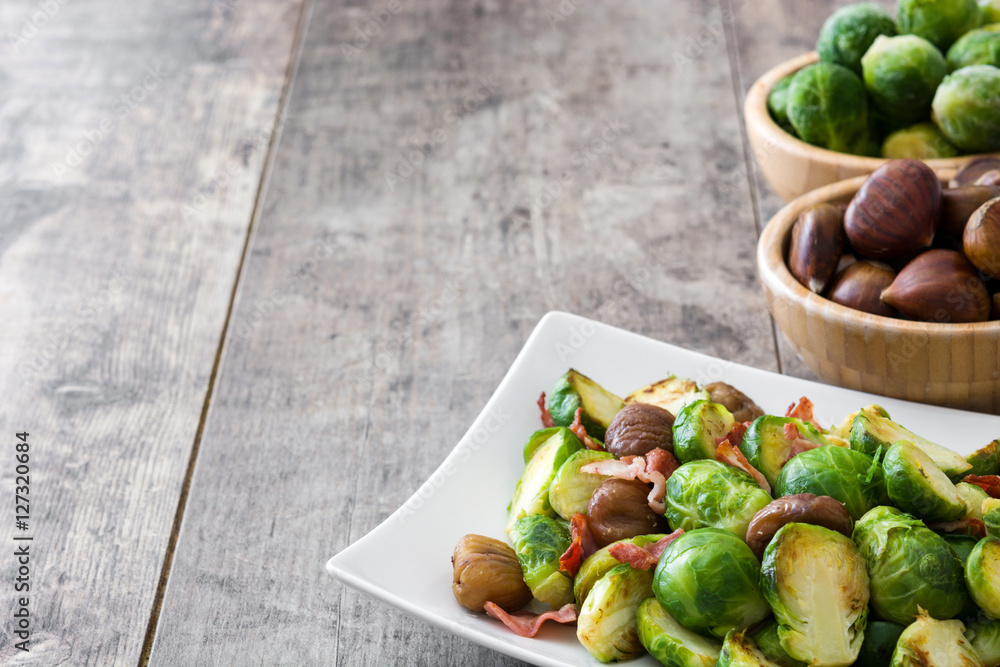 Brussels sprouts with chestnuts and bacon on wooden table
Brussels sprouts with chestnuts and bacon on wooden table