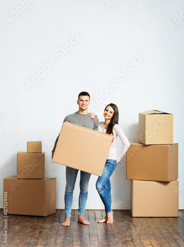 Young couple holding boxes in their new home