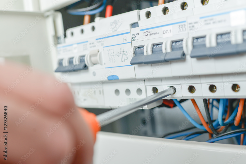 Hand turning screwdriver in fuse box Hand turning screwdriver in fuse box