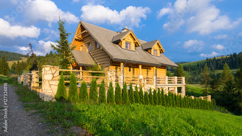 Fototapeta Naklejka Na Ścianę i Meble -  Traditional wooden mountain house built from wood logs on summer sunny day