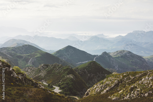 Sunset in the mountain natural landscape park. Green valley on background dramatic sky and clouds. Panorama  horizon view of scenery  foggy hills Northern Spain alps. Travel mockup concept in evening © A_B_C