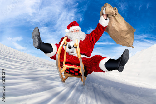 santa claus jumping on a sleigh crazy fast funny with his bag on christmas gift present delivery / Weihnachtsmann rasant lustiug schnell auf Schlitten