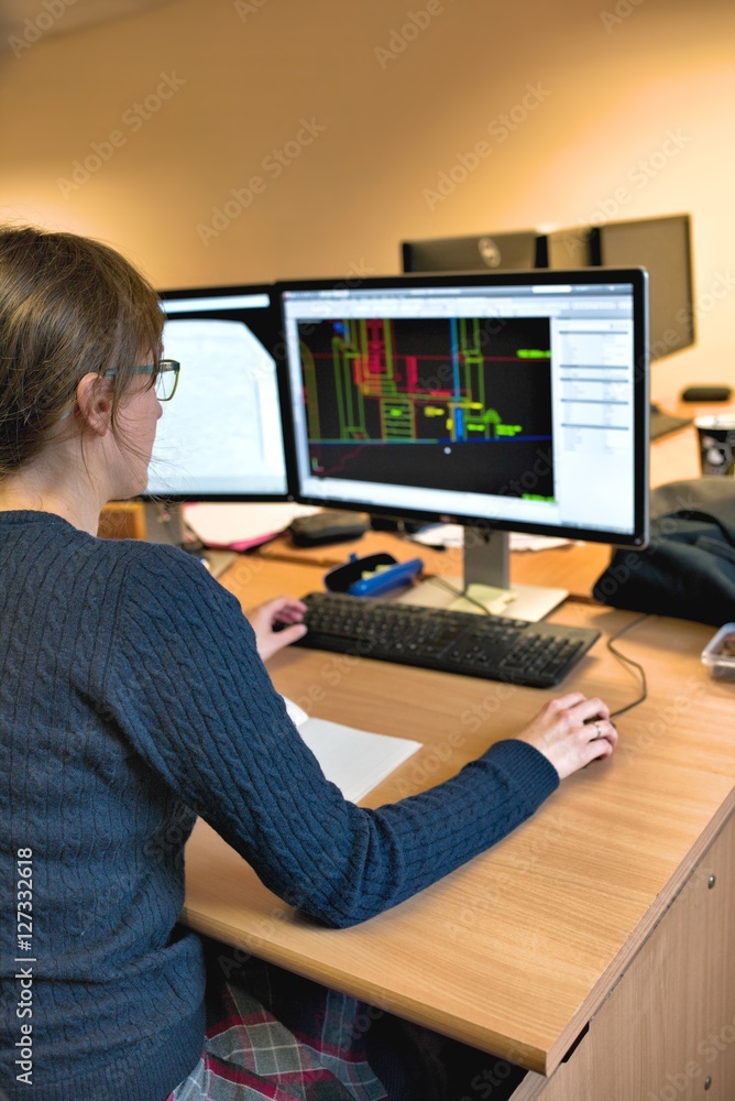 Young woman working in office on computer. Female architect in g Young woman working in office on computer. Female architect in g