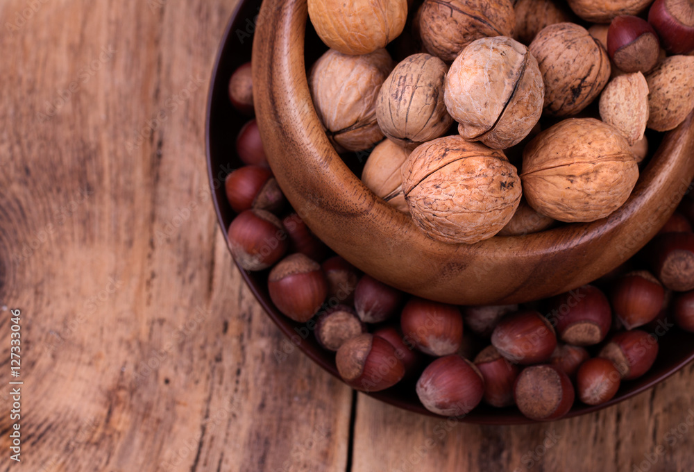 Walnuts and hazelnuts on rustic wooden background Walnuts and hazelnuts on rustic wooden background