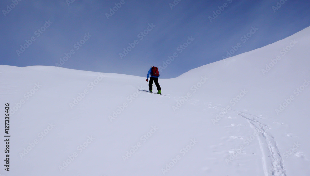 a backcountry skier climbing a mountain in the Swiss Alps near St. Moritz