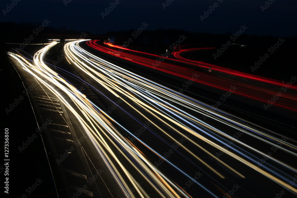 stripes of cars on an highway at night