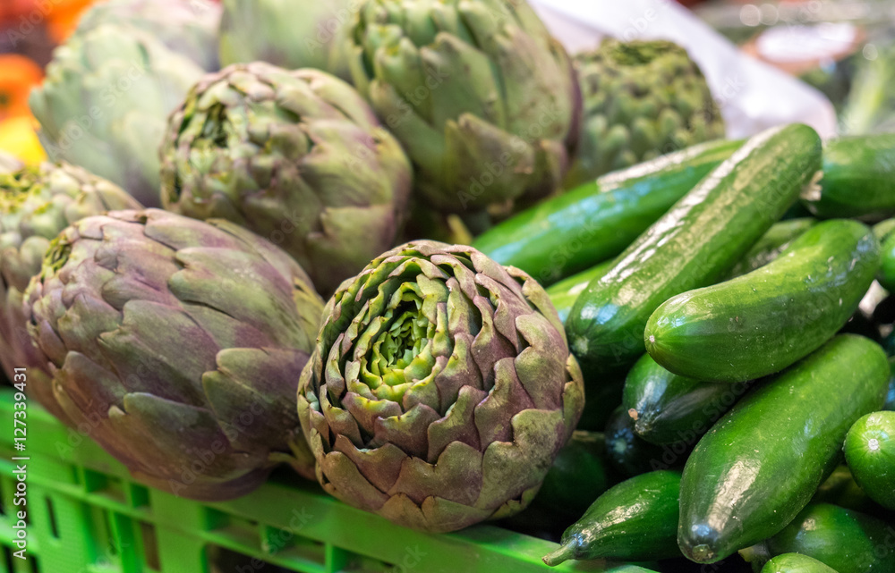 Fototapeta premium artichokes and cucumbers in a box for sale at the local market