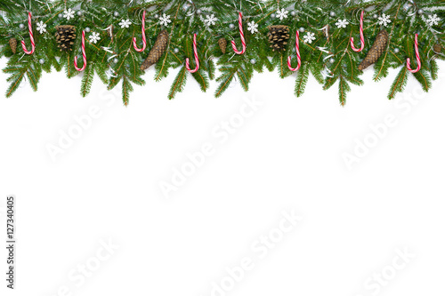 Christmas long decoration with red lollipops, snowflakes, cones and silver ribbons on artificial snow. White background.