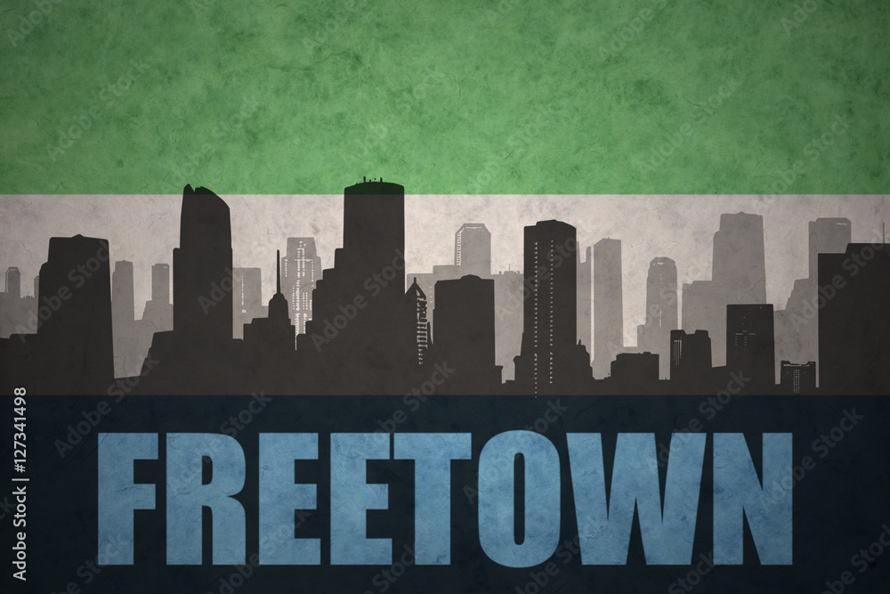 abstract silhouette of the city with text Freetown at the vintage sierra leone flag