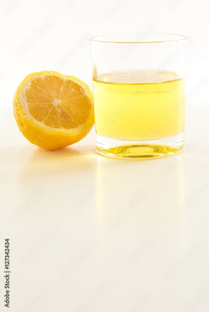 lemon and a glass of lemonade on a white background
