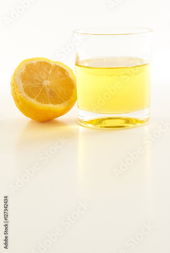 lemon and a glass of lemonade on a white background