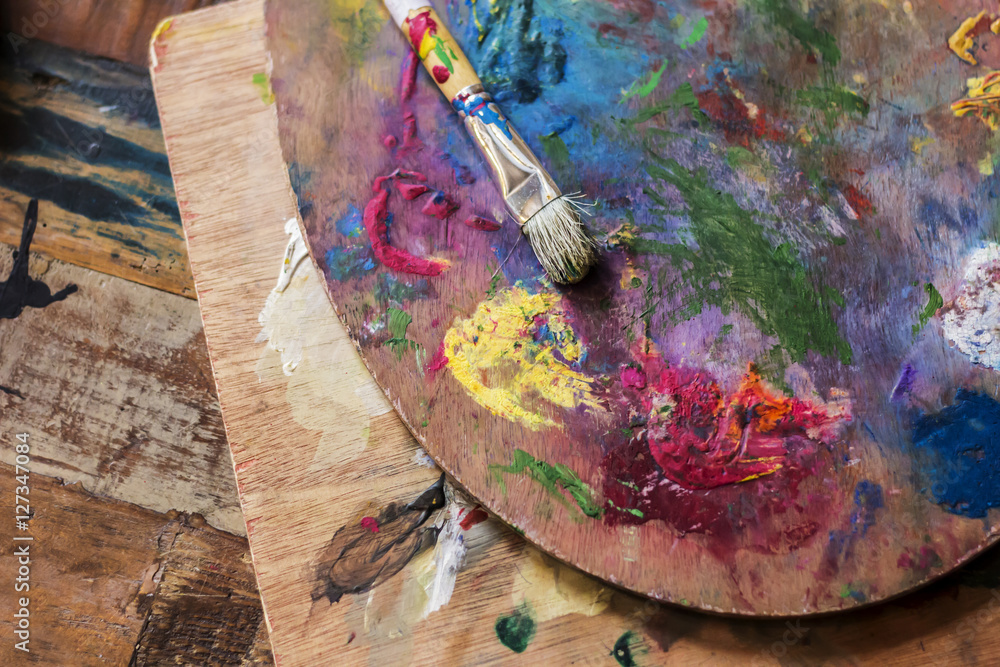 Used Artist paint brush and palette of colorful oil paint on wooden  background for drawing and painting Stock Photo