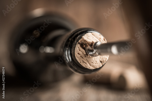 Corkscrew screwed into cork in bottle of wine