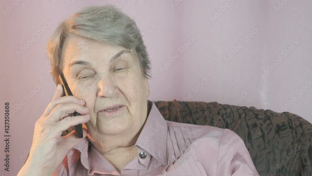 Old woman smiling talks on mobile phone. Close up Old woman smiling talks on mobile phone. Close up