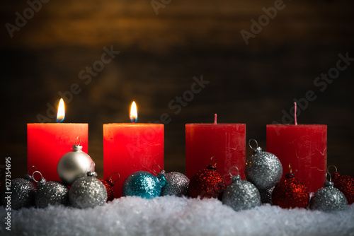 Weihnachtsschmuck und 4 Kerzen von denen zwei symbolisch für den 2. Advent leuchten photo