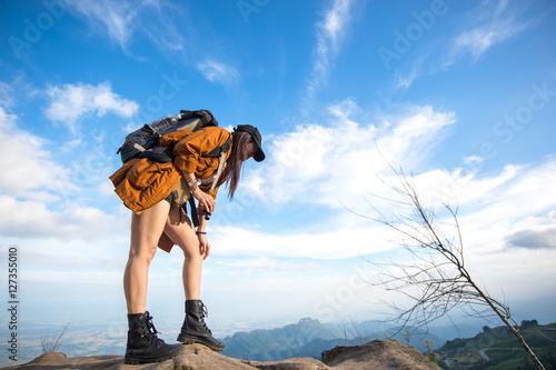 Hiker woman look binoculars on the mountain, background blue sky, Thailand, select and soft focus © freebird7977