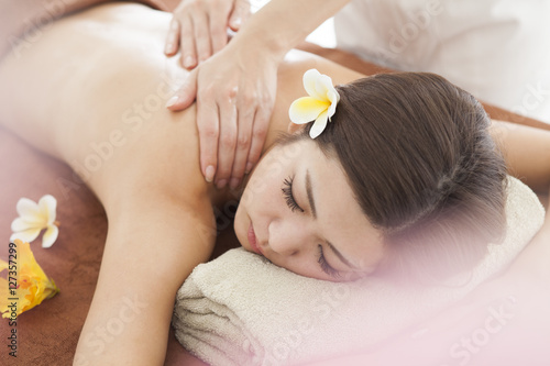 The woman is undergoing a back massage