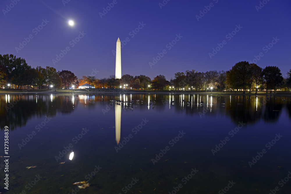Washington Monument at night with full moon and reflection in pond, Washington DC, USA