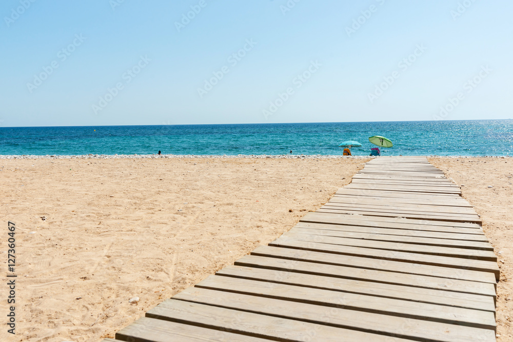 Walkway leading to Mediterranean Sea white stony beach of Alicante.