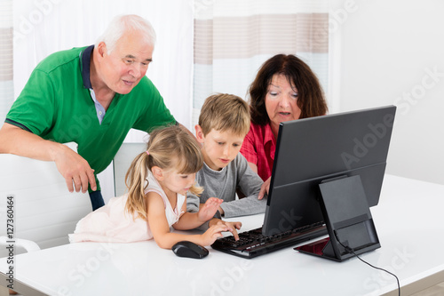 Multi Generation Family Using Desktop At Home