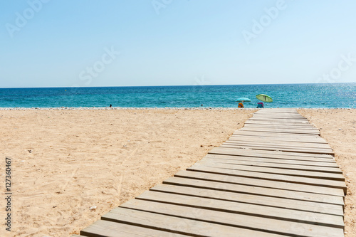 Walkway leading to Mediterranean Sea white stony beach of Alicante.