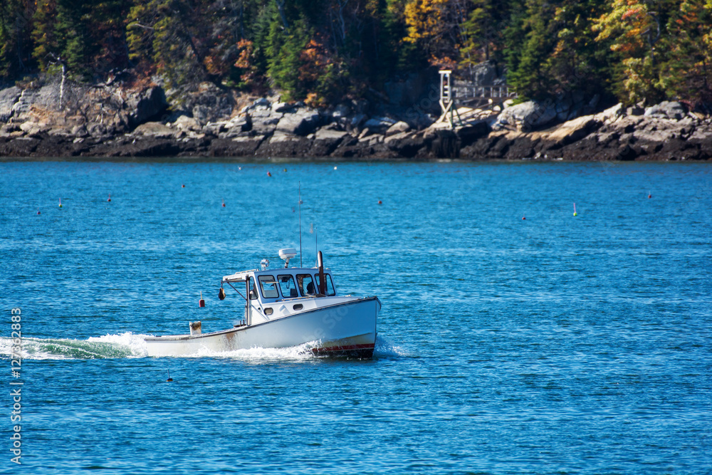 Lobster fishing boat in autumn against deep blue ocean water in coastal Maine, New England Lobster fishing boat in autumn against deep blue ocean water in coastal Maine, New England