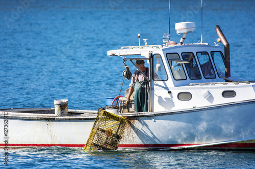 Lobster fishing boat in autumn against deep blue ocean water in coastal Maine, New England