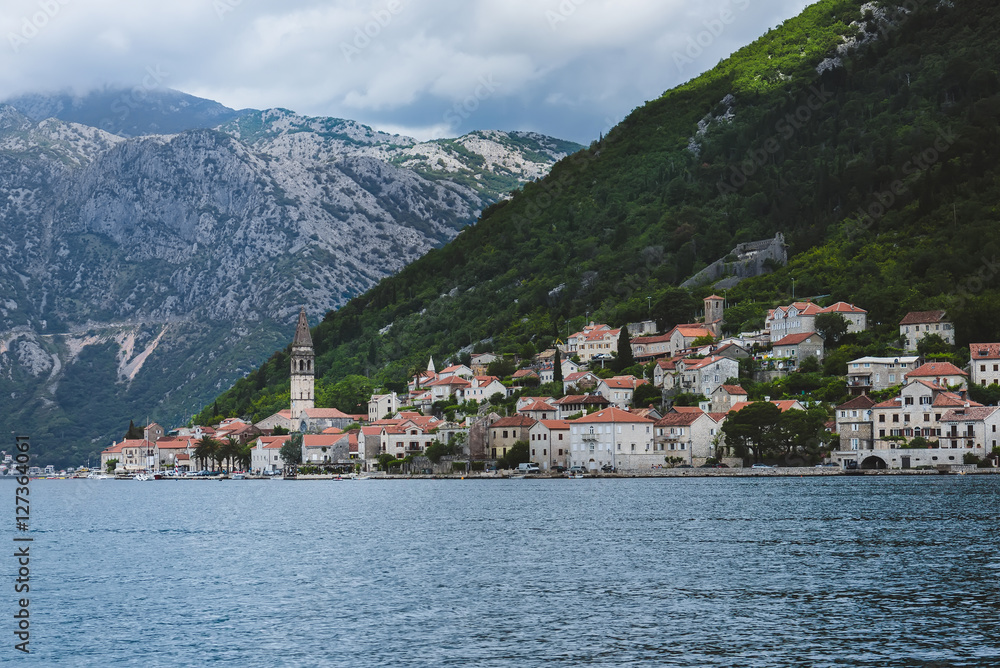 Famous ancient Perast village on Kotor bay in Montenegro. View to Perast Old Town roofs and mountains from water of Boka Kotorska.
