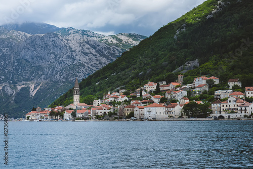 Famous ancient Perast village on Kotor bay in Montenegro. View to Perast Old Town roofs and mountains from water of Boka Kotorska.