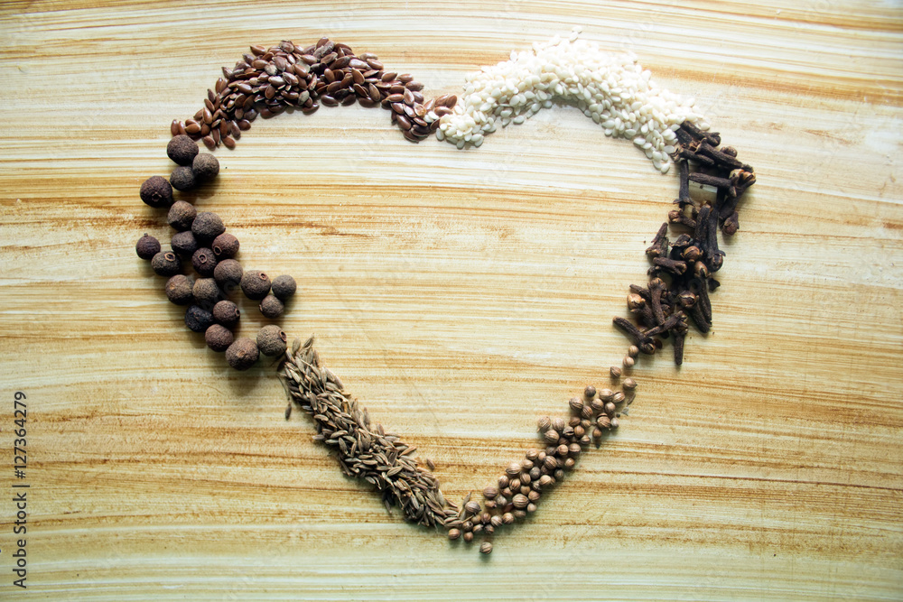 spices on a wooden background with heart shaped place for text spices on a wooden background with heart shaped place for text