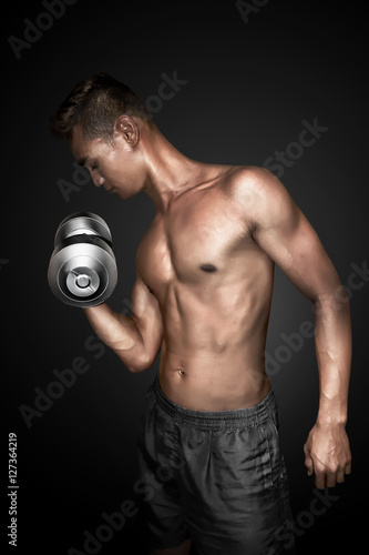 Man doing exercising lifting weights on black background © fotokitas