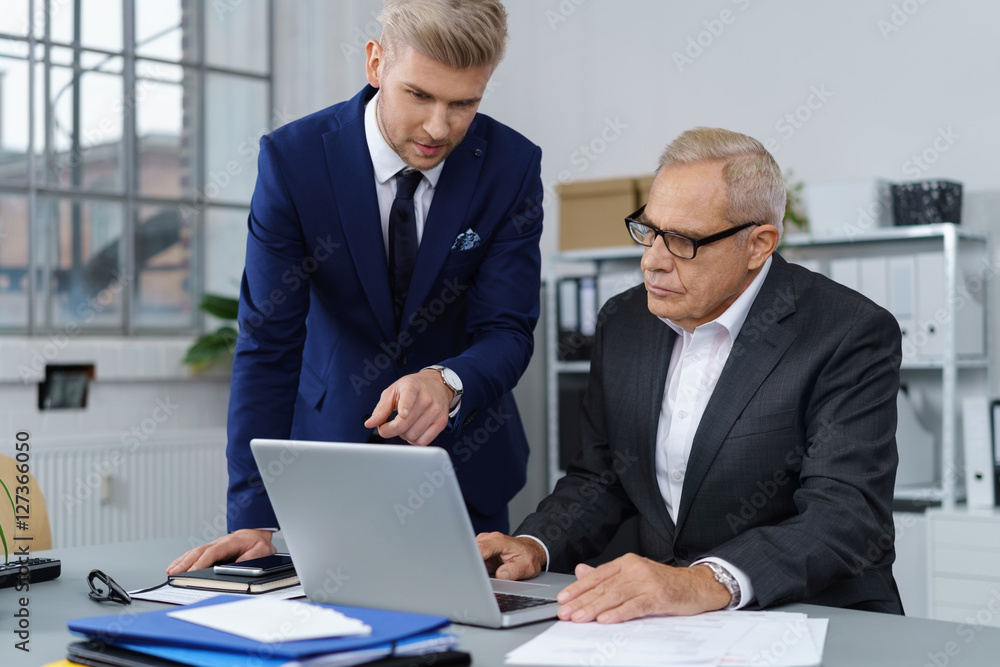 mitarbeiter zeigt seinem chef etwas am laptop mitarbeiter zeigt seinem chef etwas am laptop