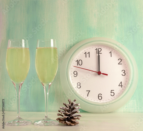 Sparkling wine with pine cone and clock showing midnight
