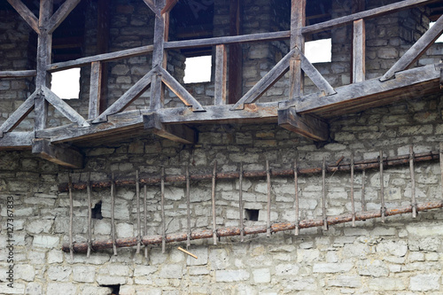 Wooden balconies and stairs on the stone wall in an old fortress