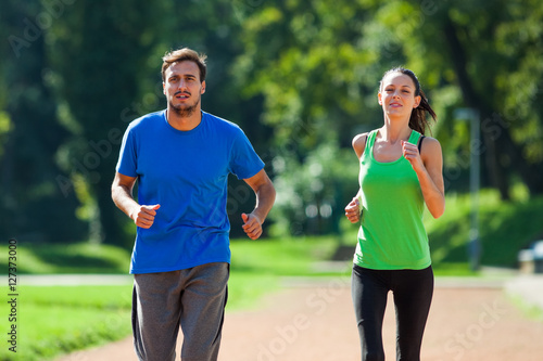Young couple is jogging on sunny day. 
