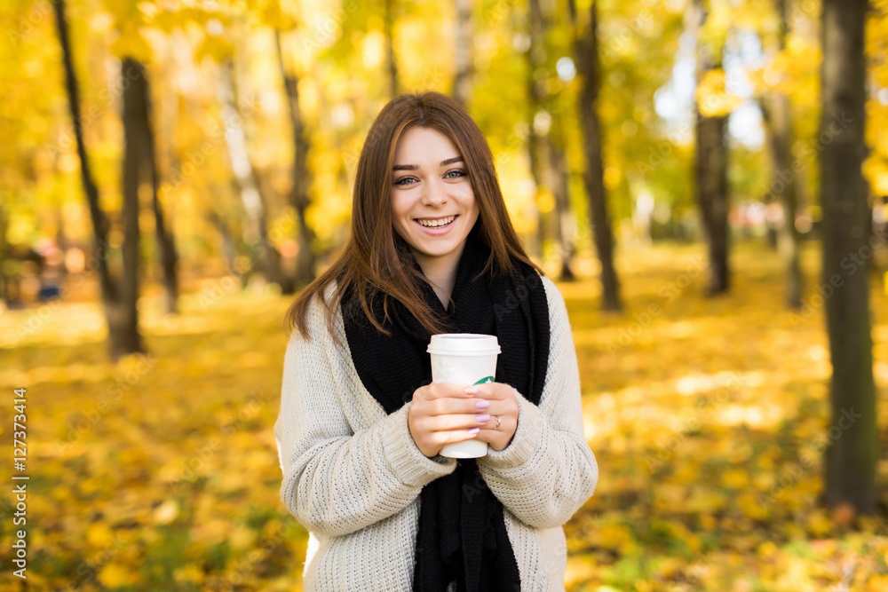 Young girl drink coffee in autumn yellow sunny park Young girl drink coffee in autumn yellow sunny park