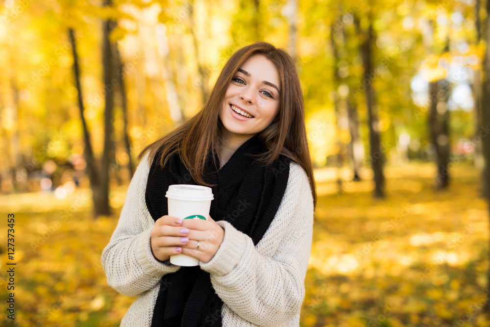 Young girl drink coffee in autumn yellow sunny park Young girl drink coffee in autumn yellow sunny park