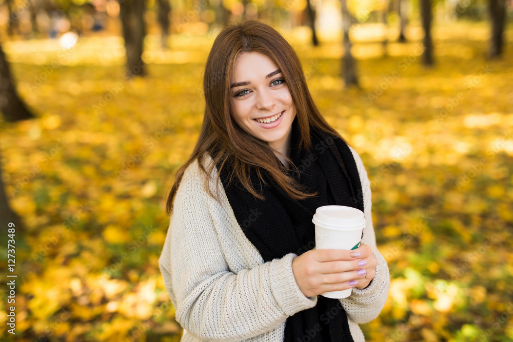 Young girl drink coffee in autumn yellow sunny park Young girl drink coffee in autumn yellow sunny park