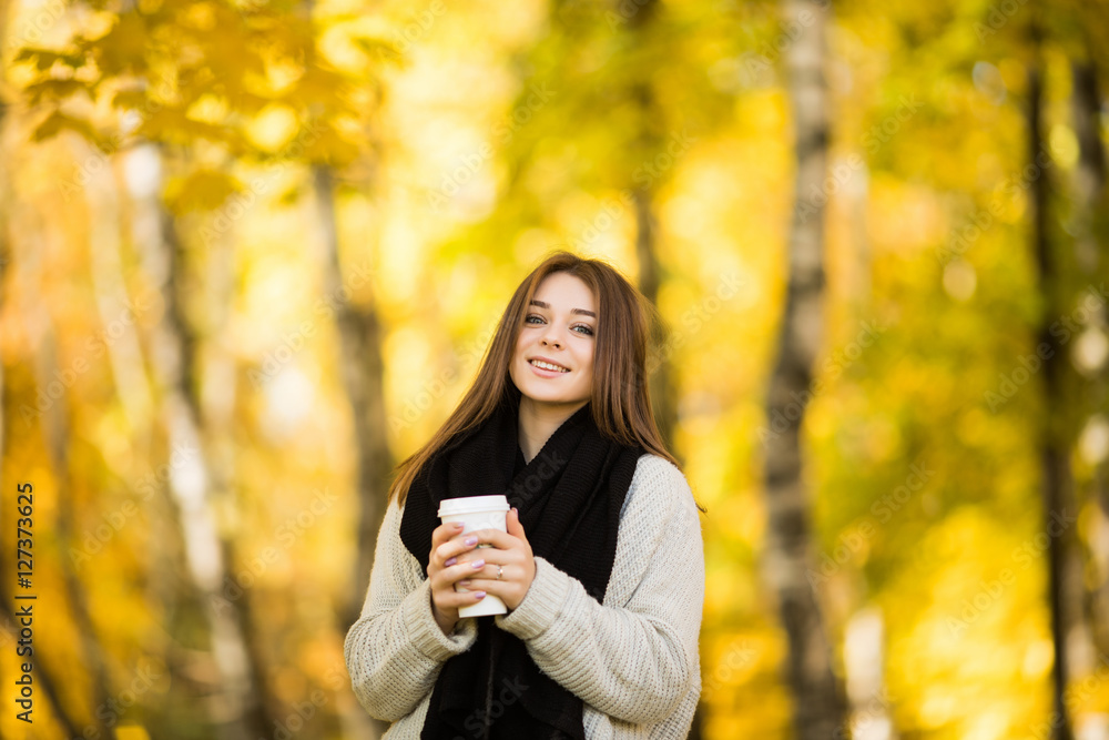 Young girl drink coffee in autumn yellow sunny park Young girl drink coffee in autumn yellow sunny park