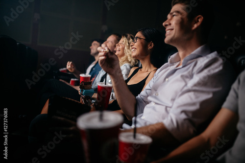 Group of people in theater with popcorn and drinks