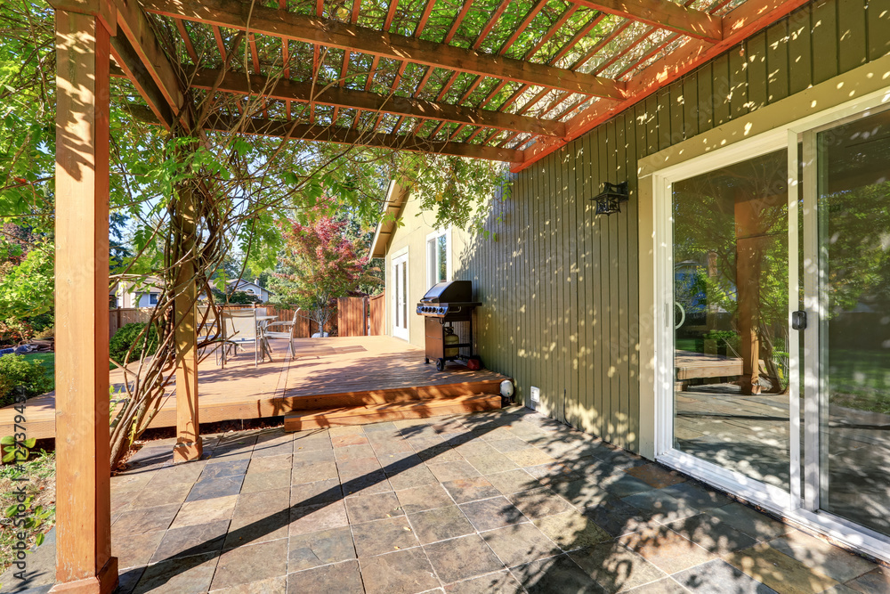 Fototapeta premium Back yard with pergola , tile floor and wooden walkout deck