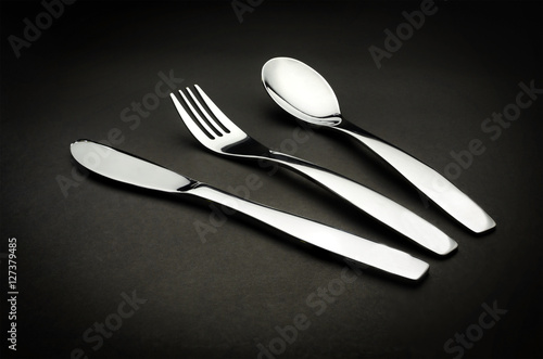 Fork, knife, spoon on back blackground